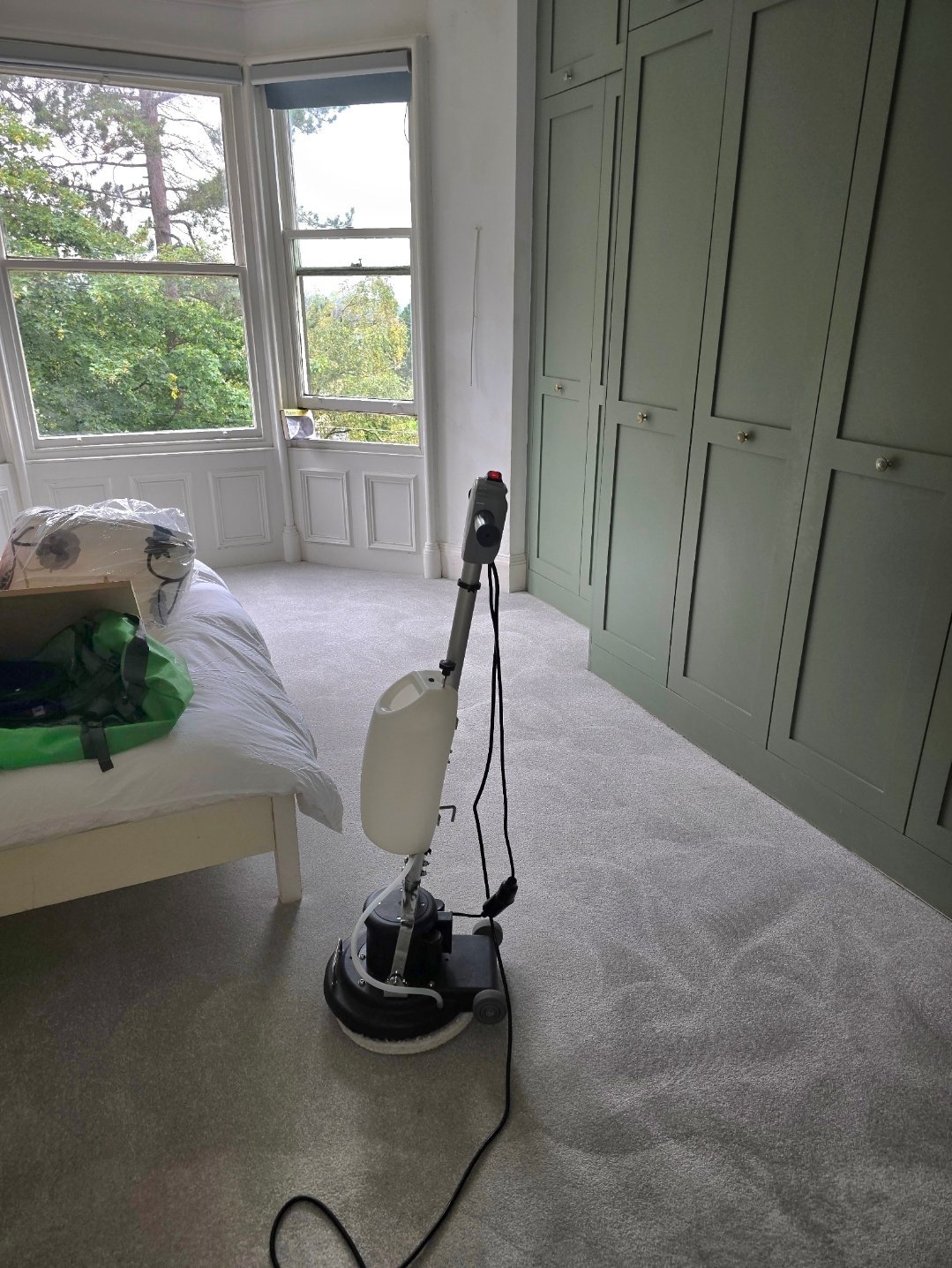 Professional carpet cleaning machine on a light grey carpet in an Ilkley bedroom