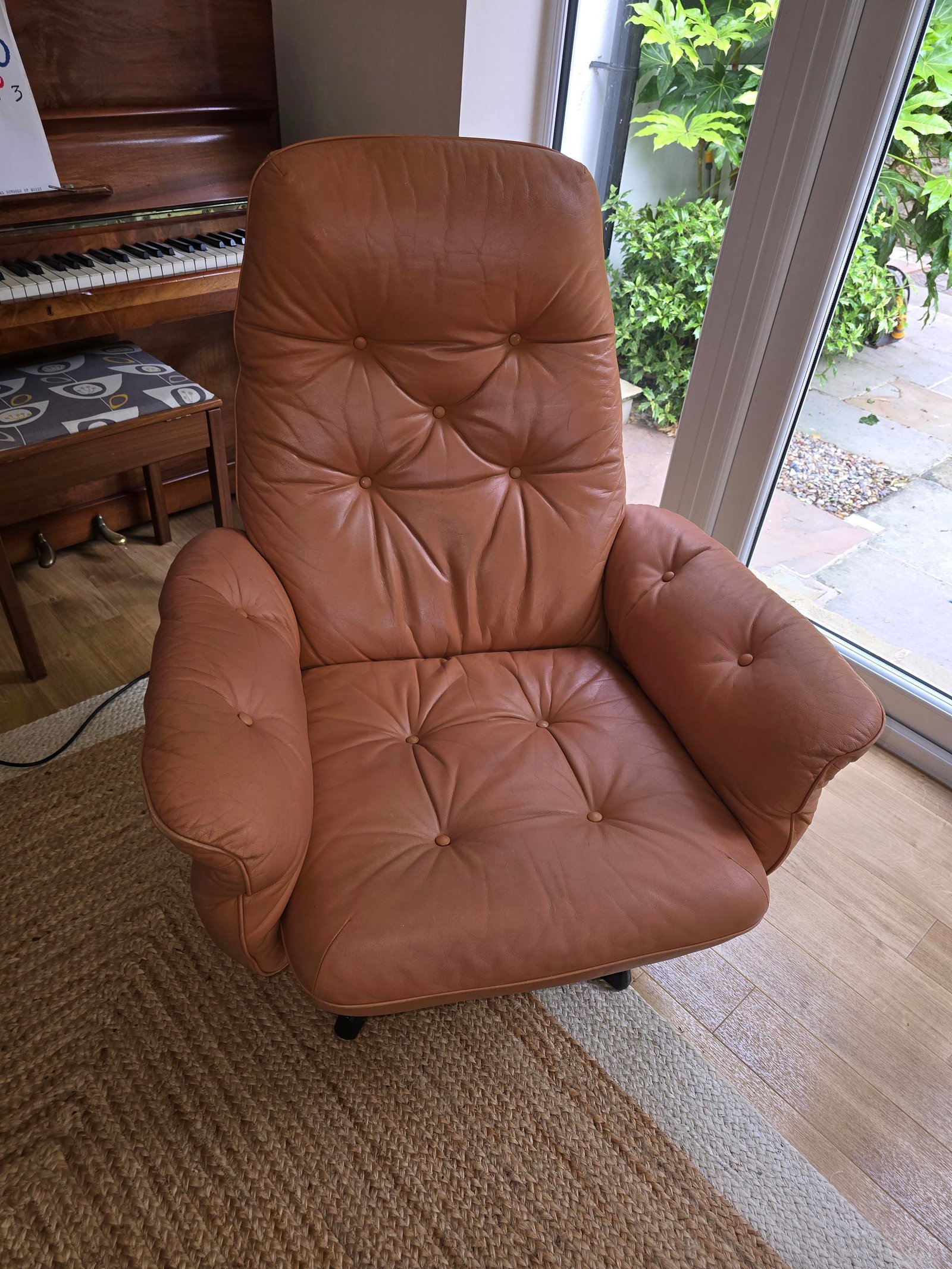 Professional leather cleaning and conditioning on a brown leather armchair